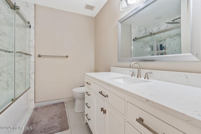 full bathroom featuring toilet, shower / bath combination with glass door, visible vents, vanity, and tile patterned floors