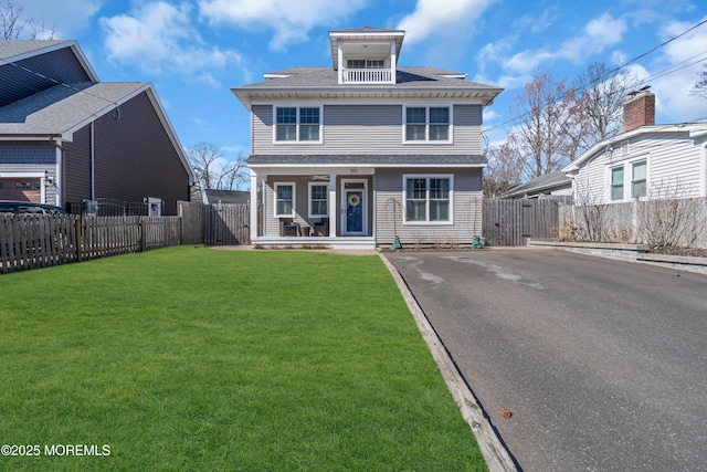 traditional style home with a fenced backyard, a porch, and a front lawn