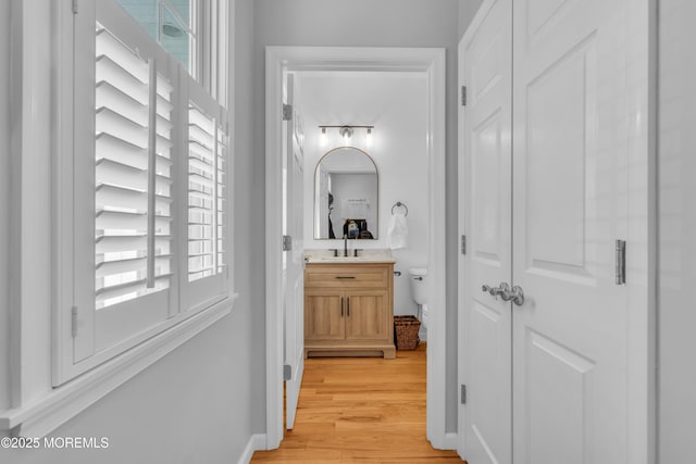 hall with light wood-type flooring and baseboards