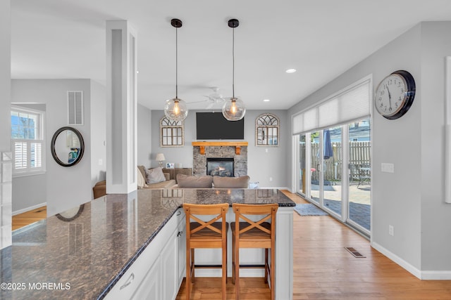 kitchen featuring plenty of natural light, light wood-style flooring, visible vents, and baseboards