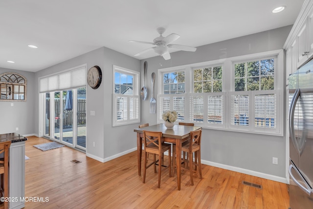 dining space featuring light wood finished floors, visible vents, and baseboards