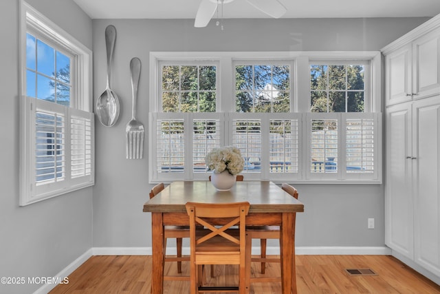 dining room featuring ceiling fan, light wood finished floors, and baseboards