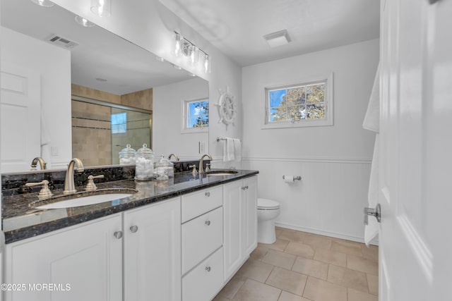 full bath with a wainscoted wall, visible vents, a wealth of natural light, and a sink