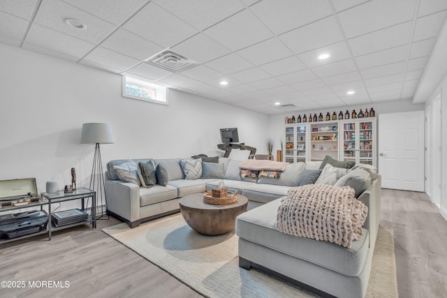 living room featuring a paneled ceiling, visible vents, wood finished floors, and recessed lighting