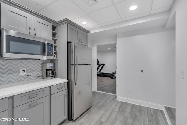 kitchen featuring visible vents, stainless steel appliances, decorative backsplash, and gray cabinetry