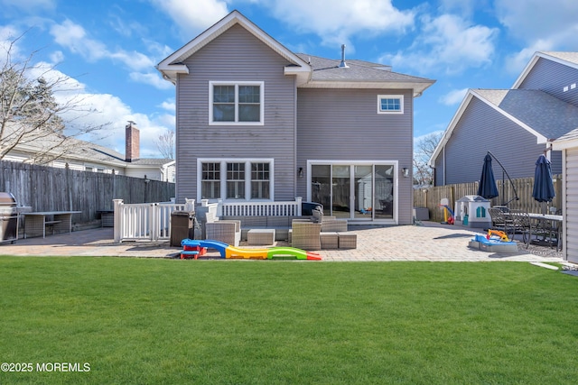 rear view of house featuring a patio area, a fenced backyard, an outdoor living space, and a lawn