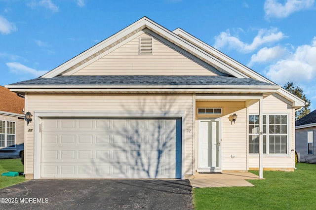 view of front facade featuring driveway, a shingled roof, a garage, and a front lawn