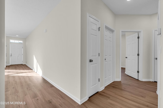 hallway with light wood-style flooring and baseboards