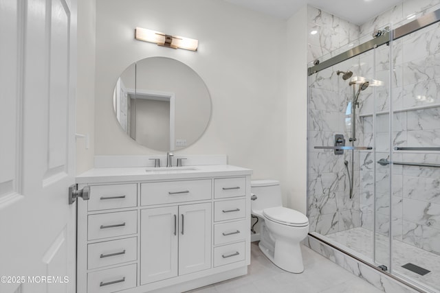 bathroom featuring a marble finish shower, vanity, and toilet