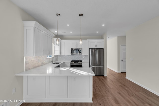 kitchen with appliances with stainless steel finishes, white cabinets, a sink, and light countertops