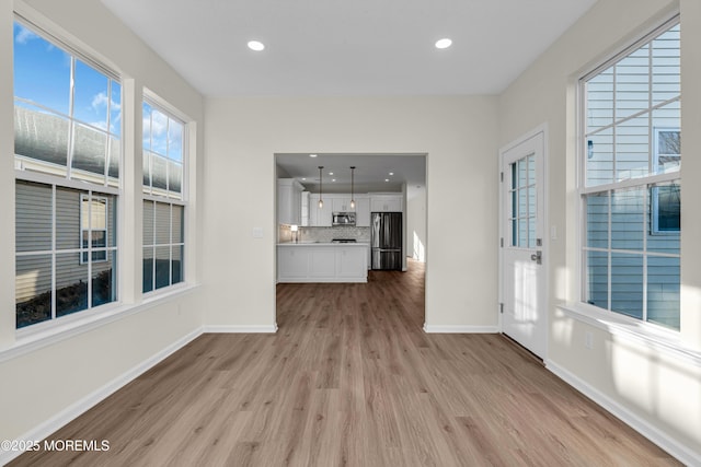 unfurnished living room with recessed lighting, baseboards, and wood finished floors