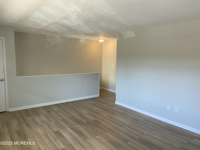 unfurnished room featuring baseboards and wood finished floors