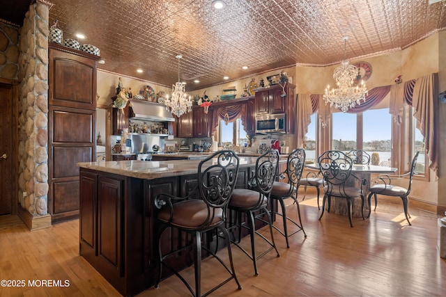 kitchen with stainless steel microwave, an ornate ceiling, and an inviting chandelier