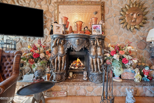 living room featuring a lit fireplace and wood finished floors