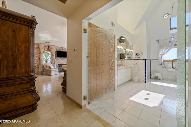 full bathroom with tile patterned floors, visible vents, high vaulted ceiling, a shower stall, and a fireplace