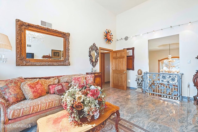 living room with visible vents, a high ceiling, and marble finish floor