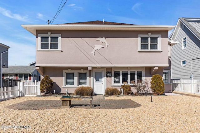 view of front facade featuring fence and stucco siding