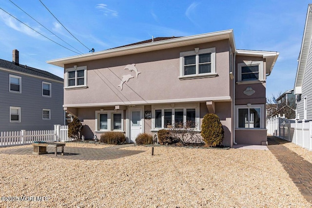 view of front of property featuring fence and stucco siding