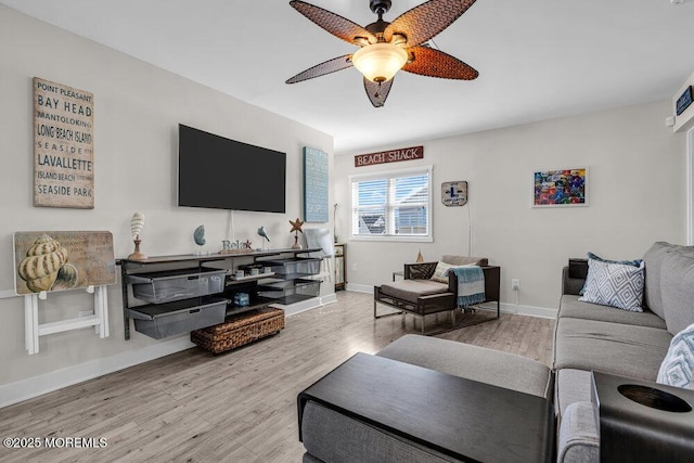 living room with ceiling fan, baseboards, and wood finished floors