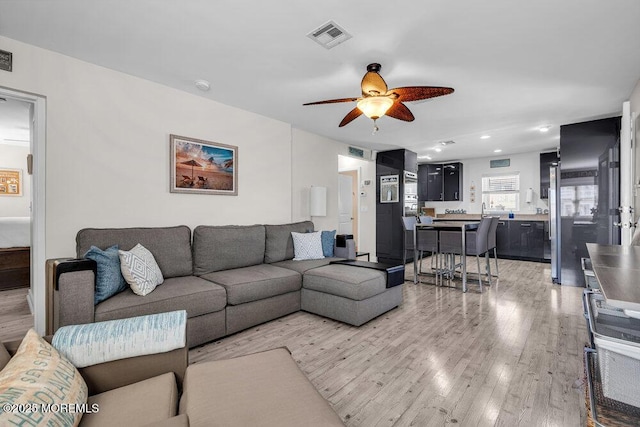 living area featuring light wood-style floors, recessed lighting, visible vents, and ceiling fan