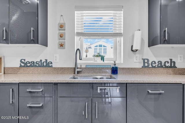 kitchen with dishwasher, a sink, and gray cabinetry