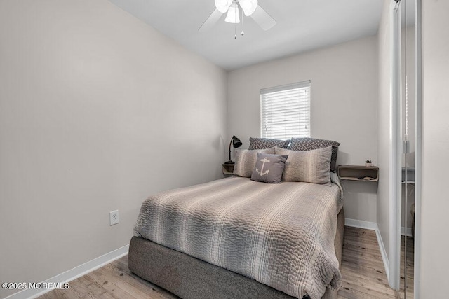 bedroom featuring ceiling fan, baseboards, and wood finished floors