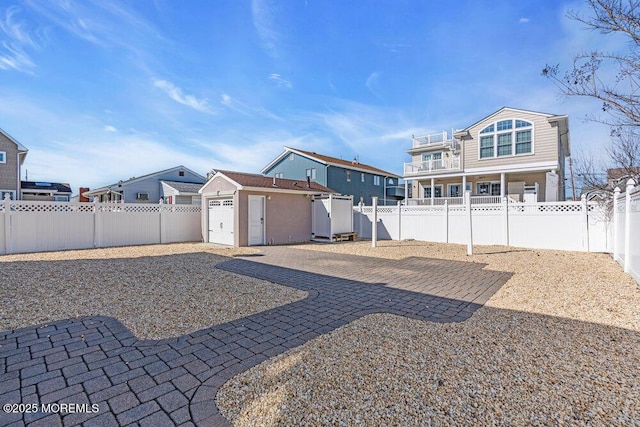 exterior space with an outbuilding, a fenced backyard, a patio, and a storage shed