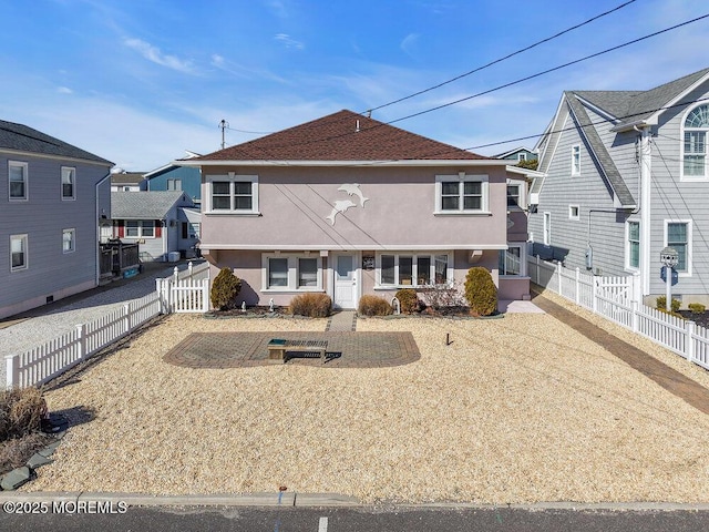 rear view of property with a fenced backyard and stucco siding