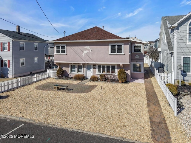 view of front of home featuring a fenced backyard and stucco siding