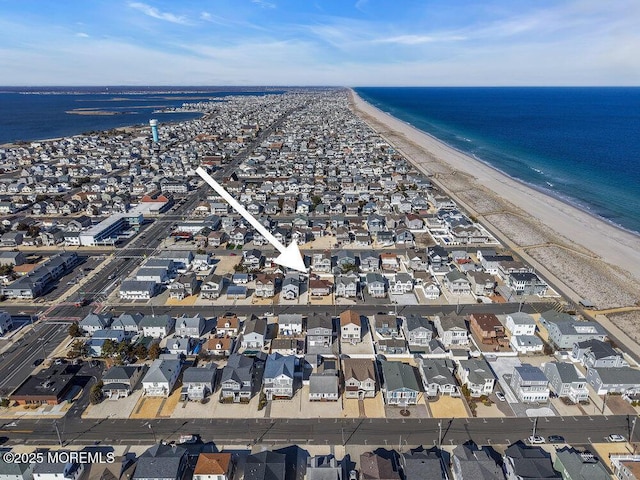 aerial view featuring a view of the beach, a water view, and a residential view