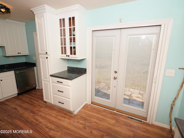 interior space featuring dark wood-style flooring, visible vents, glass insert cabinets, white cabinets, and dishwasher