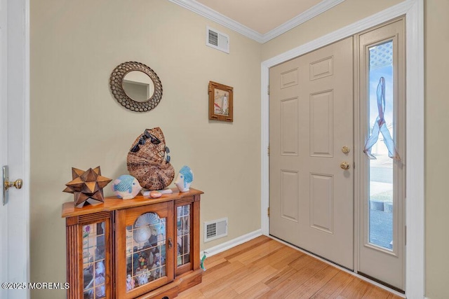 foyer featuring visible vents, baseboards, crown molding, and light wood-style floors