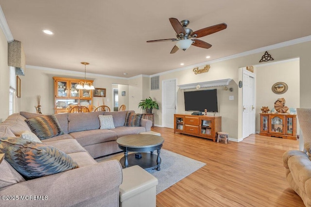 living area with light wood-type flooring, visible vents, ceiling fan with notable chandelier, crown molding, and baseboards