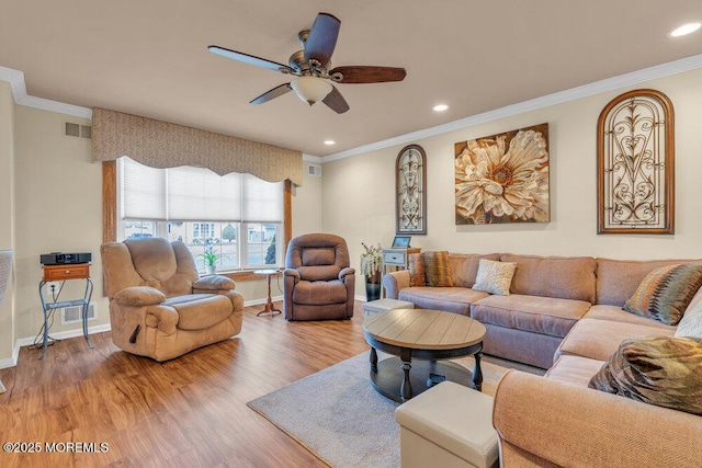 living room with wood finished floors, visible vents, and ornamental molding