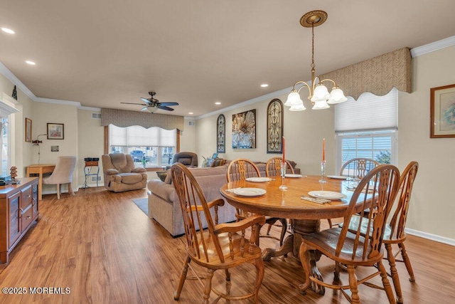 dining area with a wealth of natural light, light wood-style flooring, and crown molding