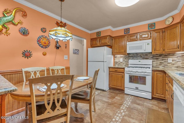 kitchen featuring hanging light fixtures, white appliances, backsplash, and ornamental molding