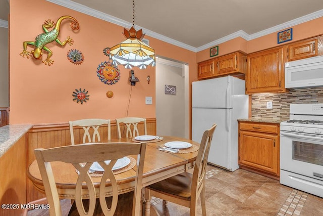 kitchen with white appliances, brown cabinetry, hanging light fixtures, crown molding, and backsplash