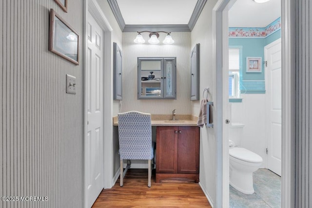 bathroom featuring vanity, toilet, crown molding, and wood finished floors