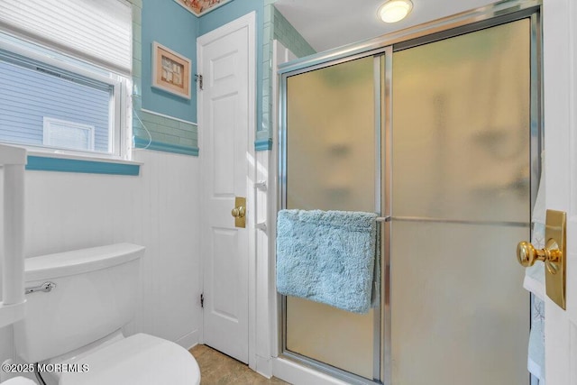 bathroom with a stall shower and toilet