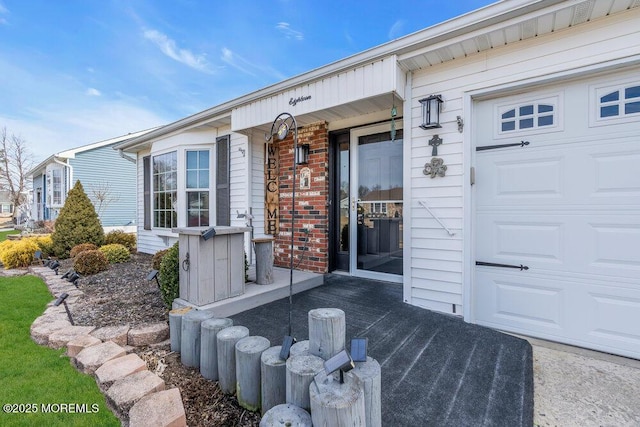 doorway to property featuring brick siding, a porch, and an attached garage