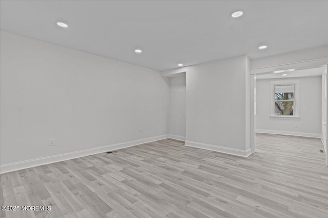 basement featuring light wood finished floors, baseboards, and recessed lighting