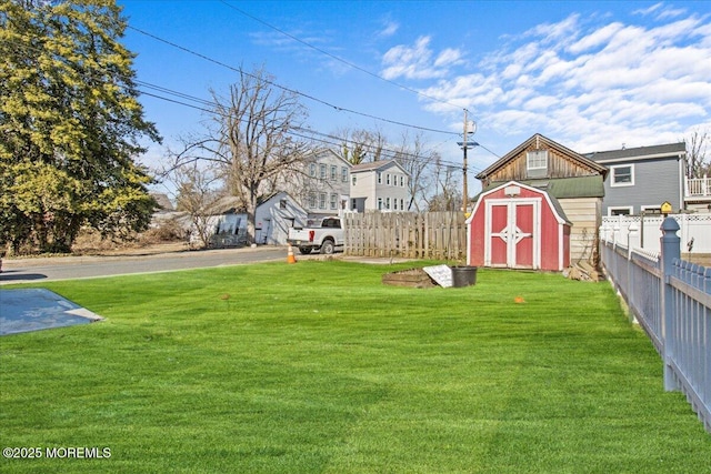 view of yard with an outbuilding, a storage unit, and fence