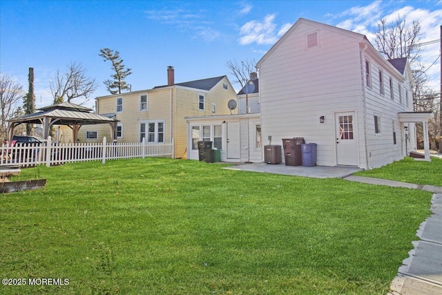 rear view of house with a gazebo, a yard, a patio, and fence