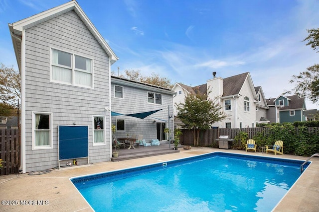 rear view of house with a patio, fence, and a fenced in pool