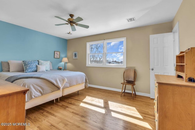 bedroom with visible vents, ceiling fan, baseboards, and wood finished floors