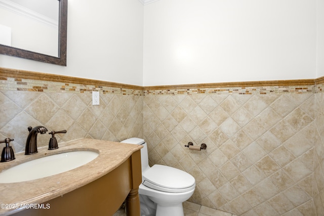 bathroom featuring toilet, tile patterned floors, tile walls, and vanity