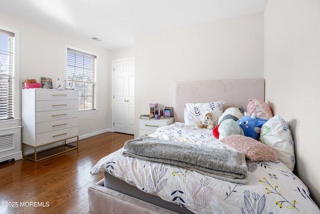 bedroom featuring wood finished floors, visible vents, and baseboards