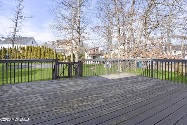 wooden deck featuring a lawn