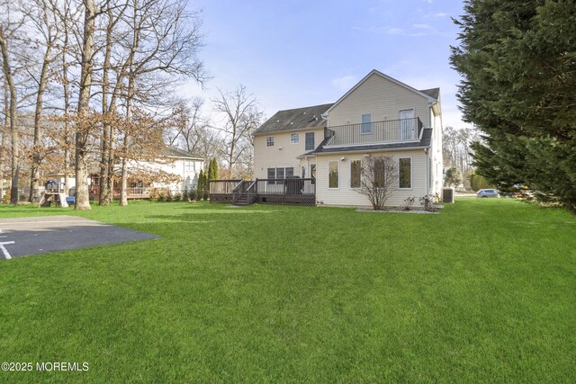 back of house with a wooden deck, a playground, cooling unit, and a yard