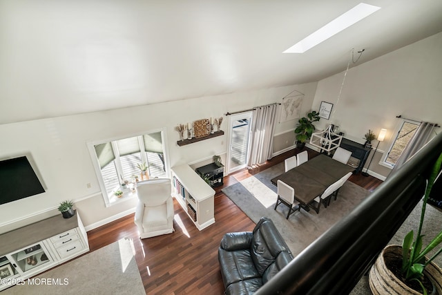 living room with lofted ceiling with skylight, a fireplace, baseboards, and wood finished floors